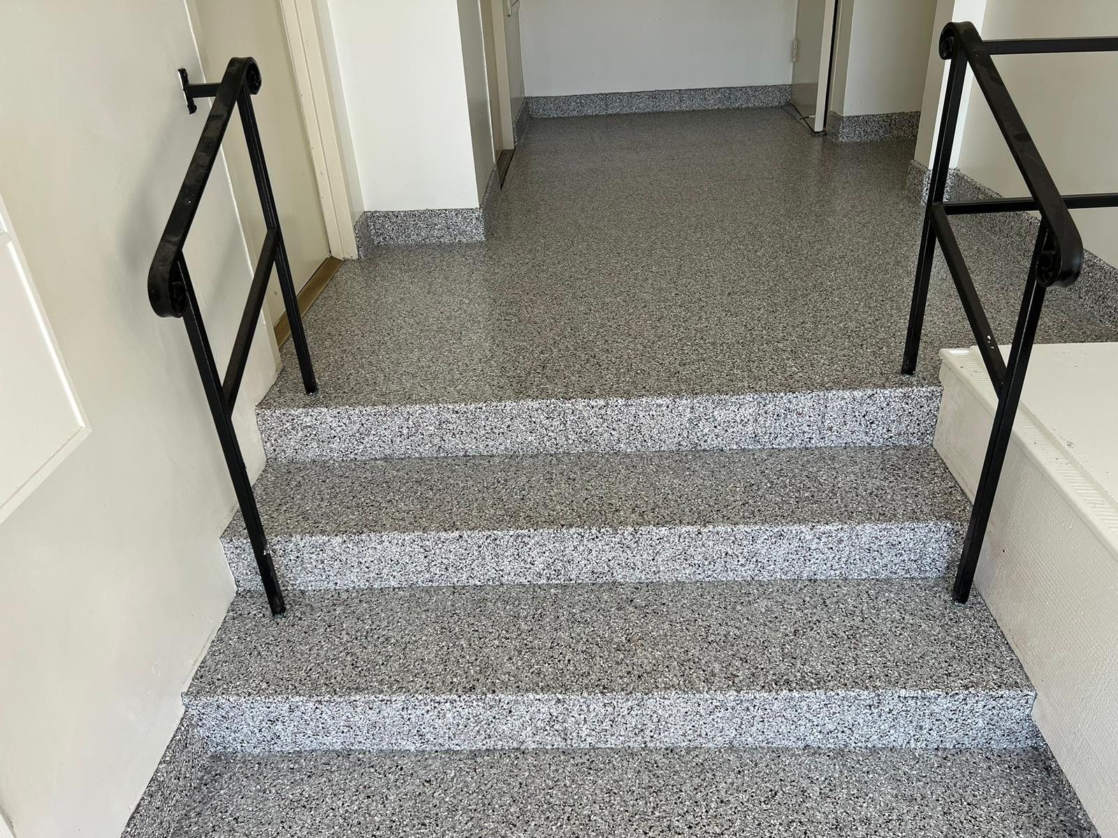 Gray flake coated entry stairs and landing with black railings