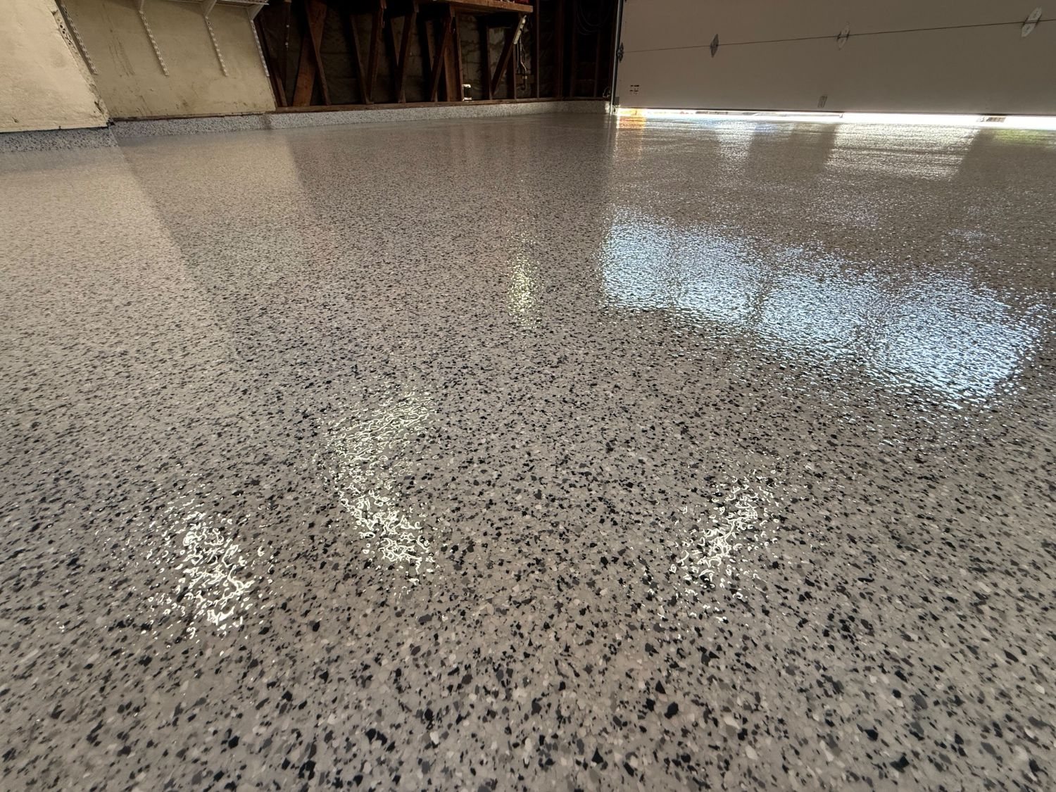Glossy gray flake epoxy garage floor under an open garage door in Los Angeles
